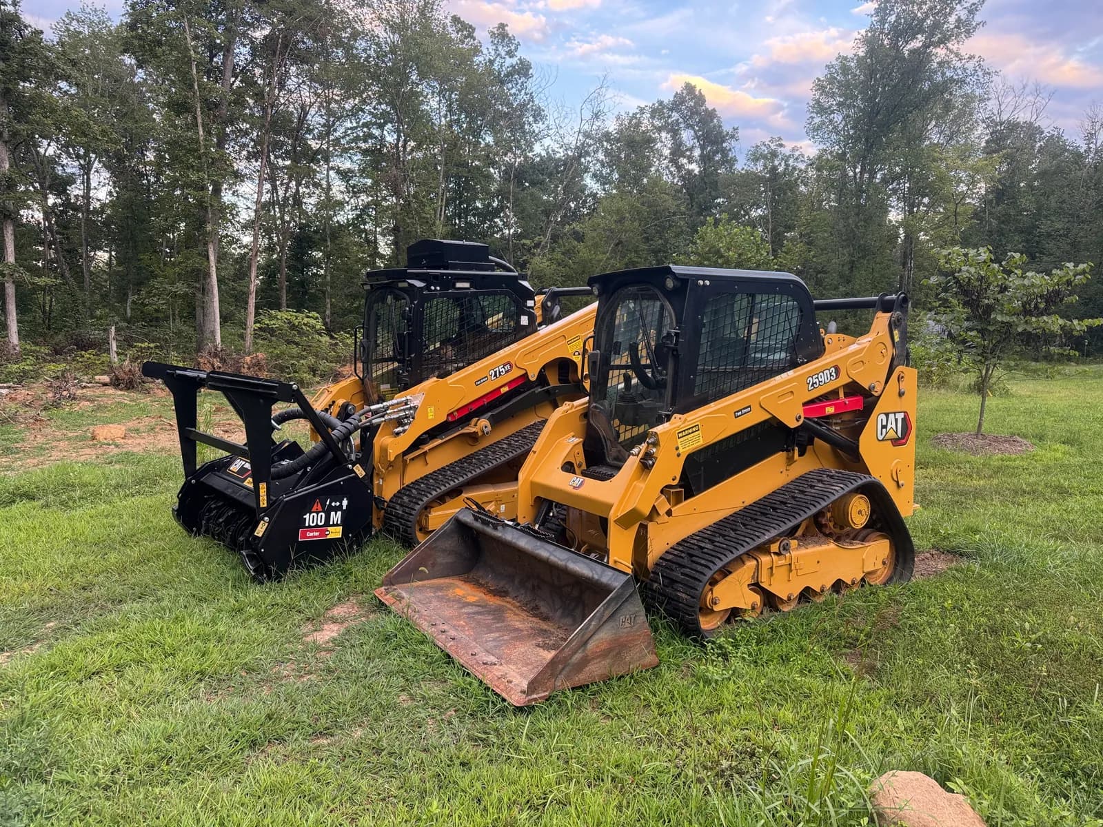 Two tracked machines at a wooded property
